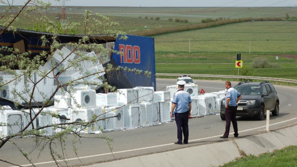 FOTO: TIR plin cu mașini de spălat, răsturnat pe șosea