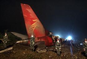 Poliţiştii chinezi păzesc avionul de pasageri care s-a prăbuşit &icirc;n Yichun.