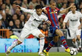 Jucătorul de la Real Madrid, Ezequiel Garay (st&acirc;nga) &icirc;şi dispută posesia balonului cu Dani Alves de la Barcelona.